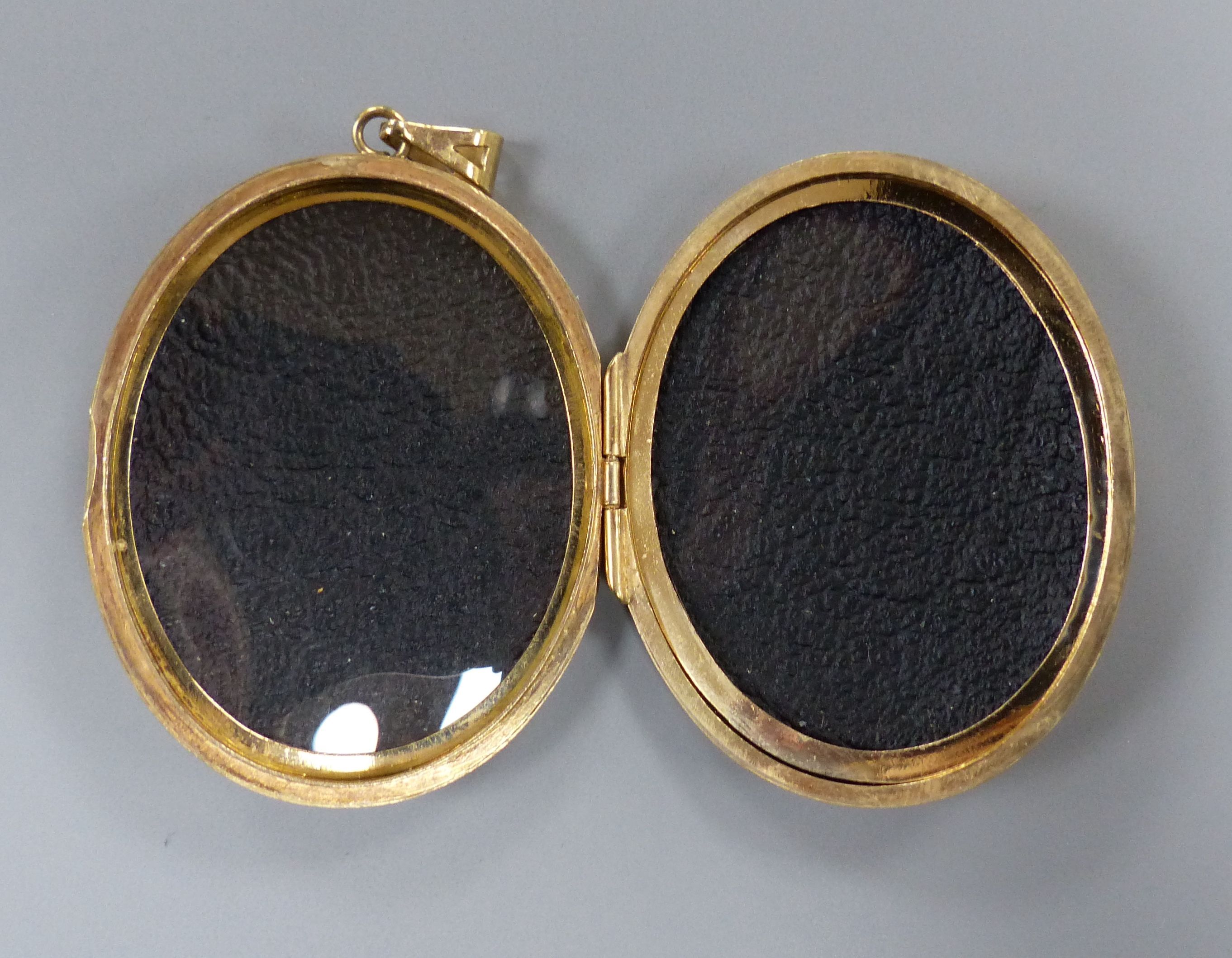 A modern engraved 9ct gold oval locket, 47mm,